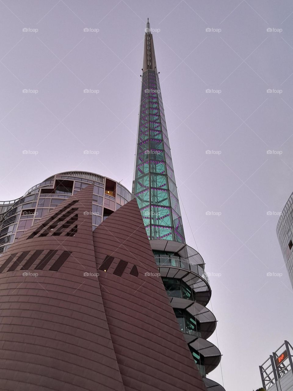 a tall turquoise tower climbing so high, light of the blue sky shining through from behind.