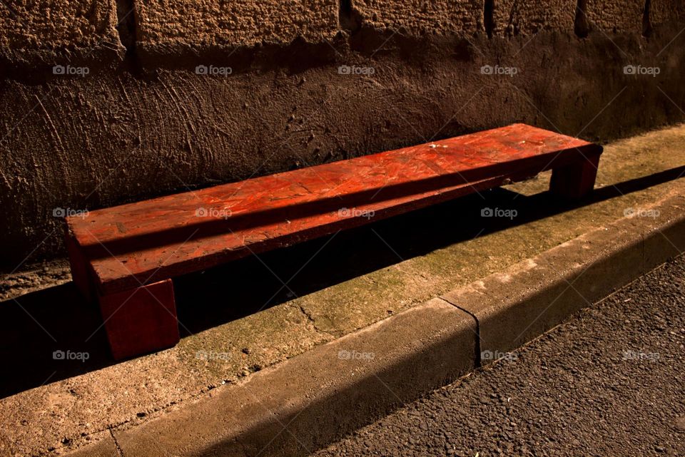 A lone bench in the urban enviroment,a reminder of a much simpler and calm life.