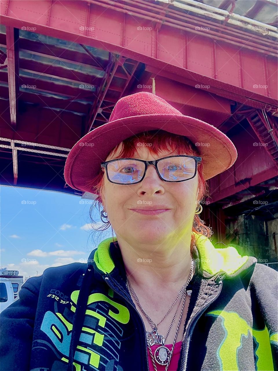 This is me, “Petra Schiller” a.k.a. “Maxine Firefox” standing in the parking lot beneath the “Pulaski Bridge” at “Newtown Creek” in LIC, Queens on a bright sunshiny day in May 2024. Hypnotic Productions