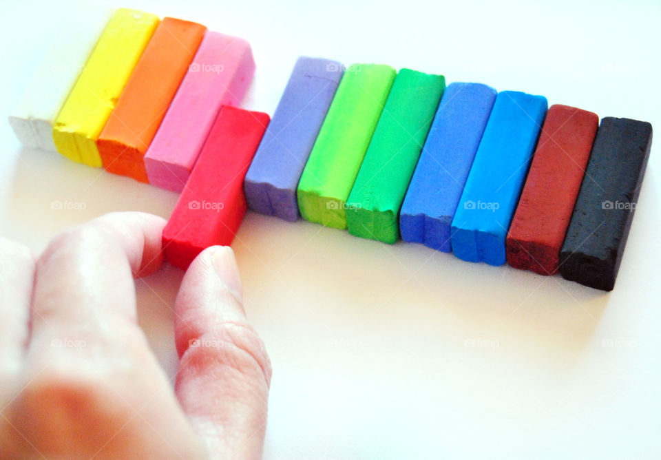 Making decisions, which chalk color, birds eye view, closeup, hands holding red chalk