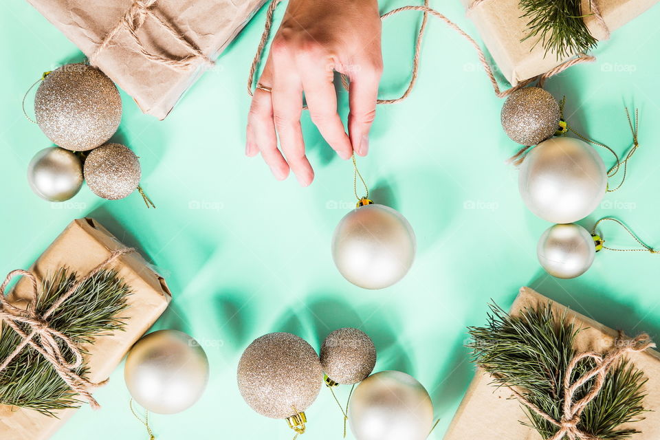 Christmas gift lying on green background. Female hand. Flatlay items. Flat lay, top view, surprise, happy new year, merry, tree, packing, packed, wrapping, celebrating, holidays, winter, background 