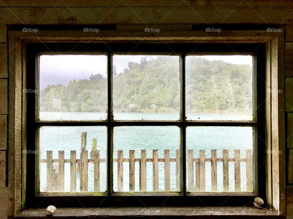 Window view of the turquoise bay beyond, New Zealand 