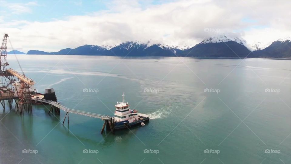 Tugboat pulling up to a dock