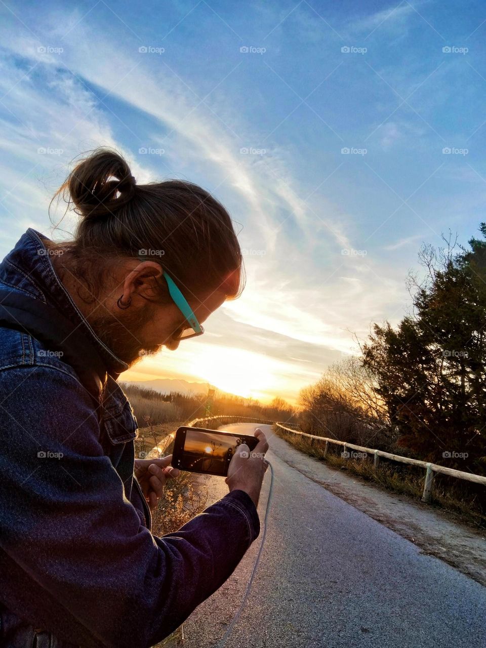 Man taking a picture of the sunset