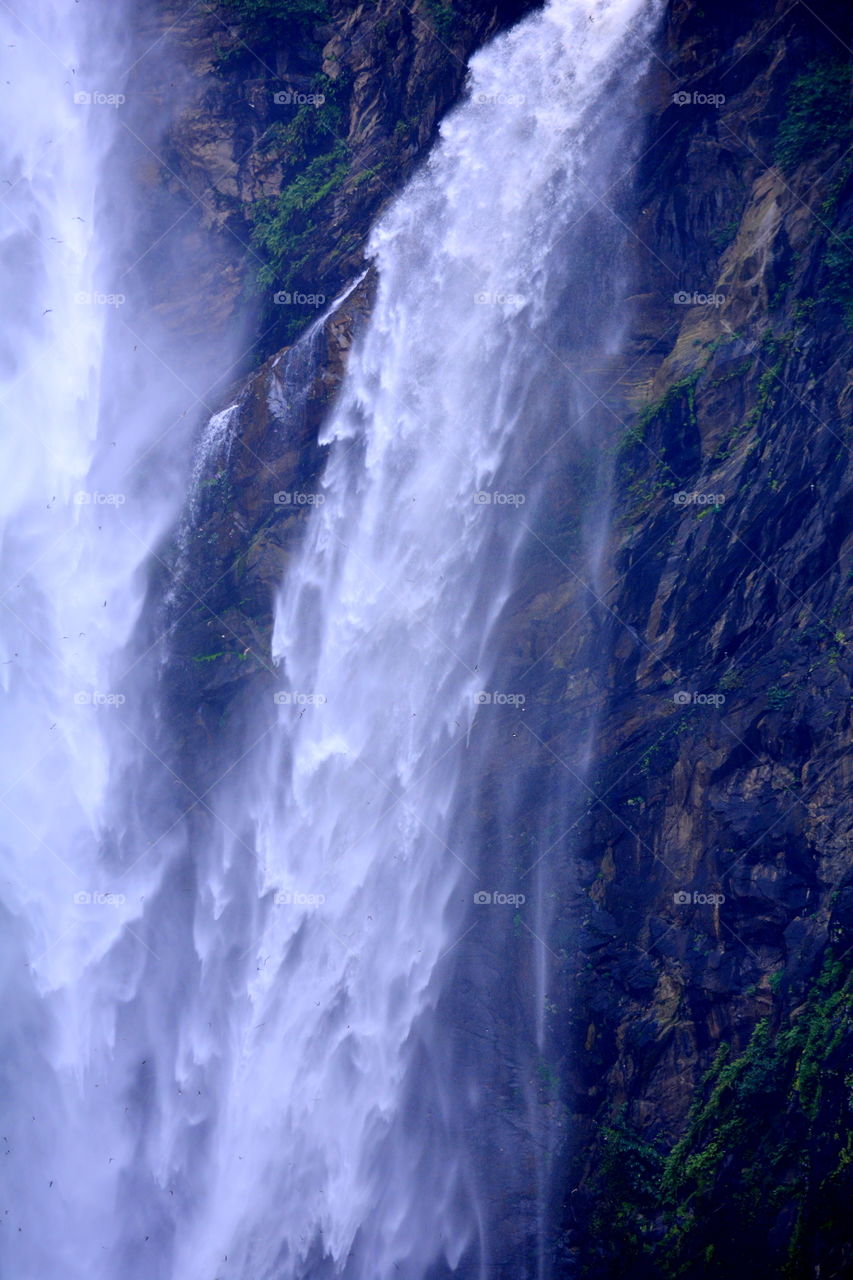jog falls, a beautiful waterfall with misty appearance and stratified rocks covered with greenery.