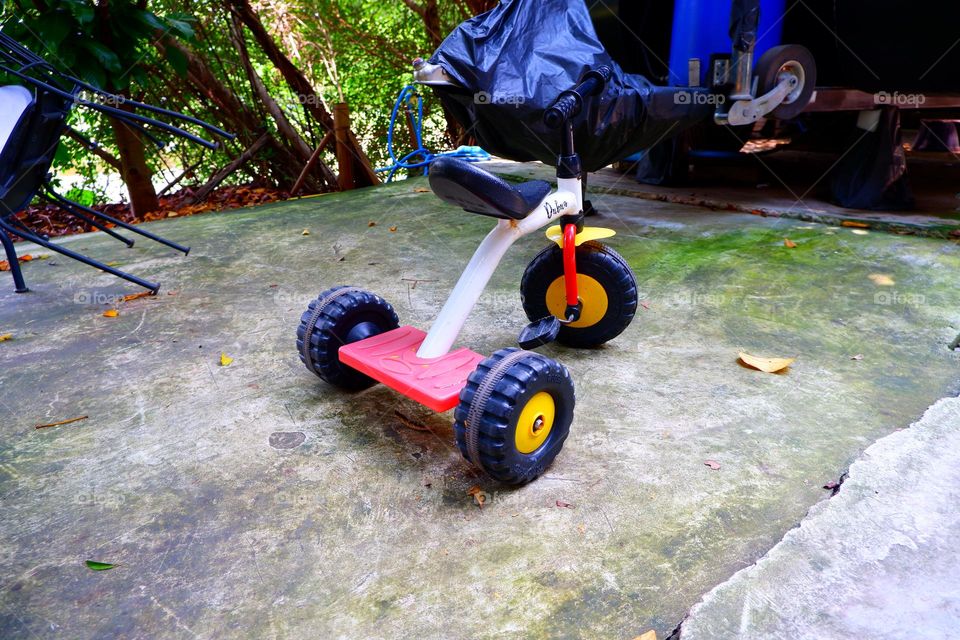 A small pedicab was parked on the concrete floor.