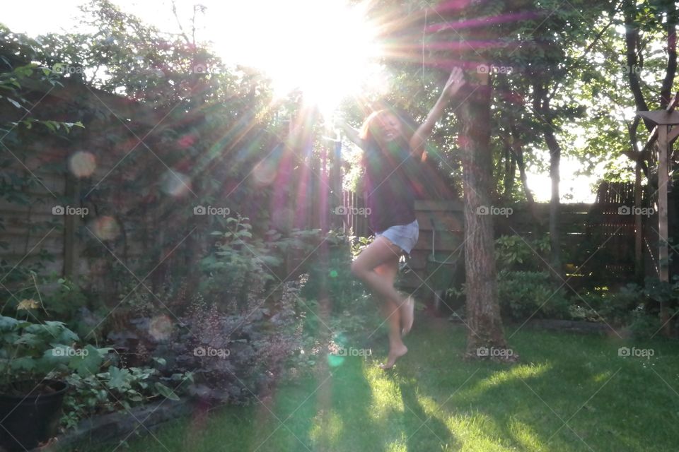 Full length Woman jumping in air against sky at dusk