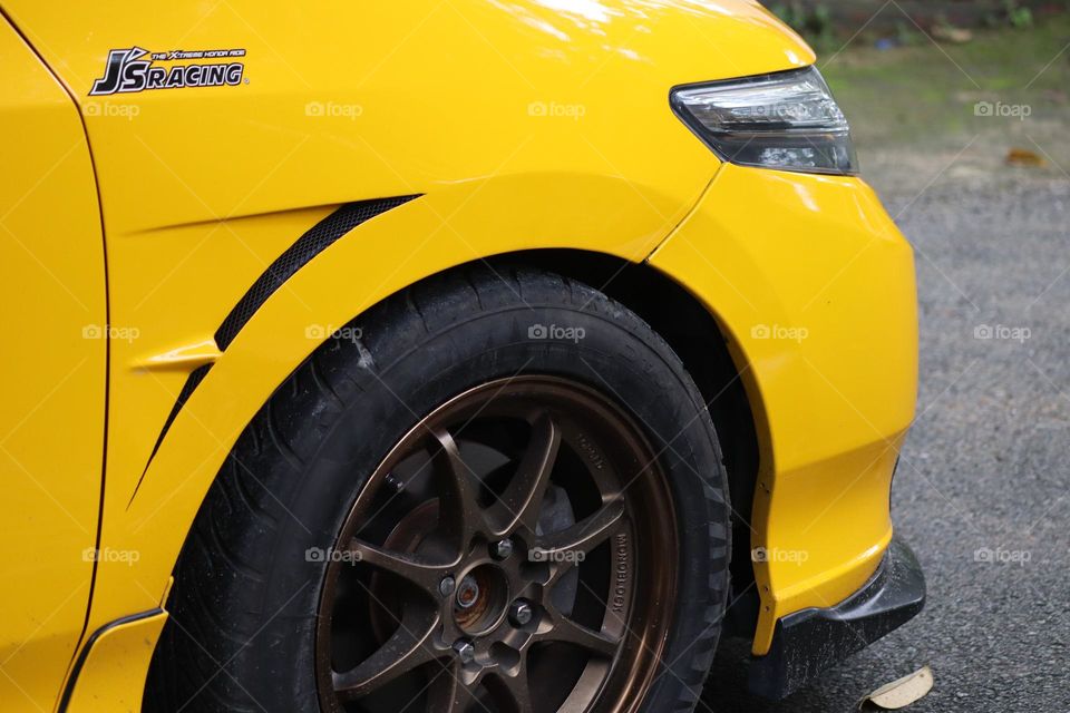 A yellow car focusing on the body and the tyre