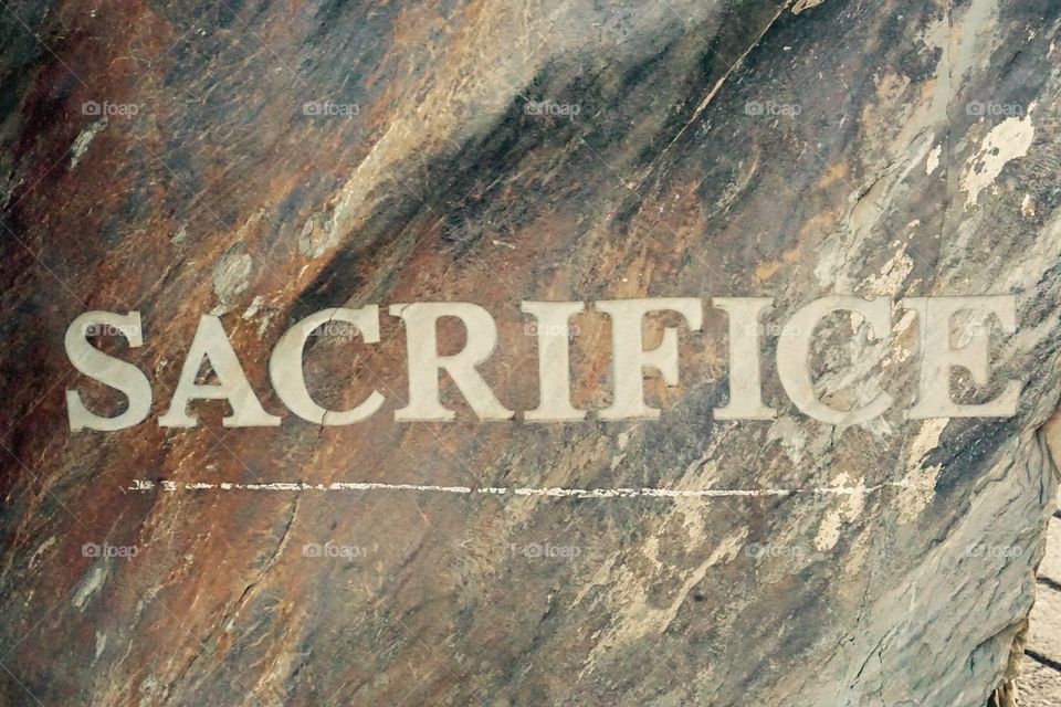 Sacrifice written in stone. Sacrifice written and chiseled in stone