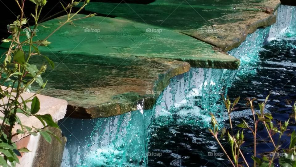 Green waterfall. green water flowing over stones