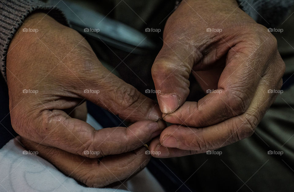 Close-up of a hand holding thread