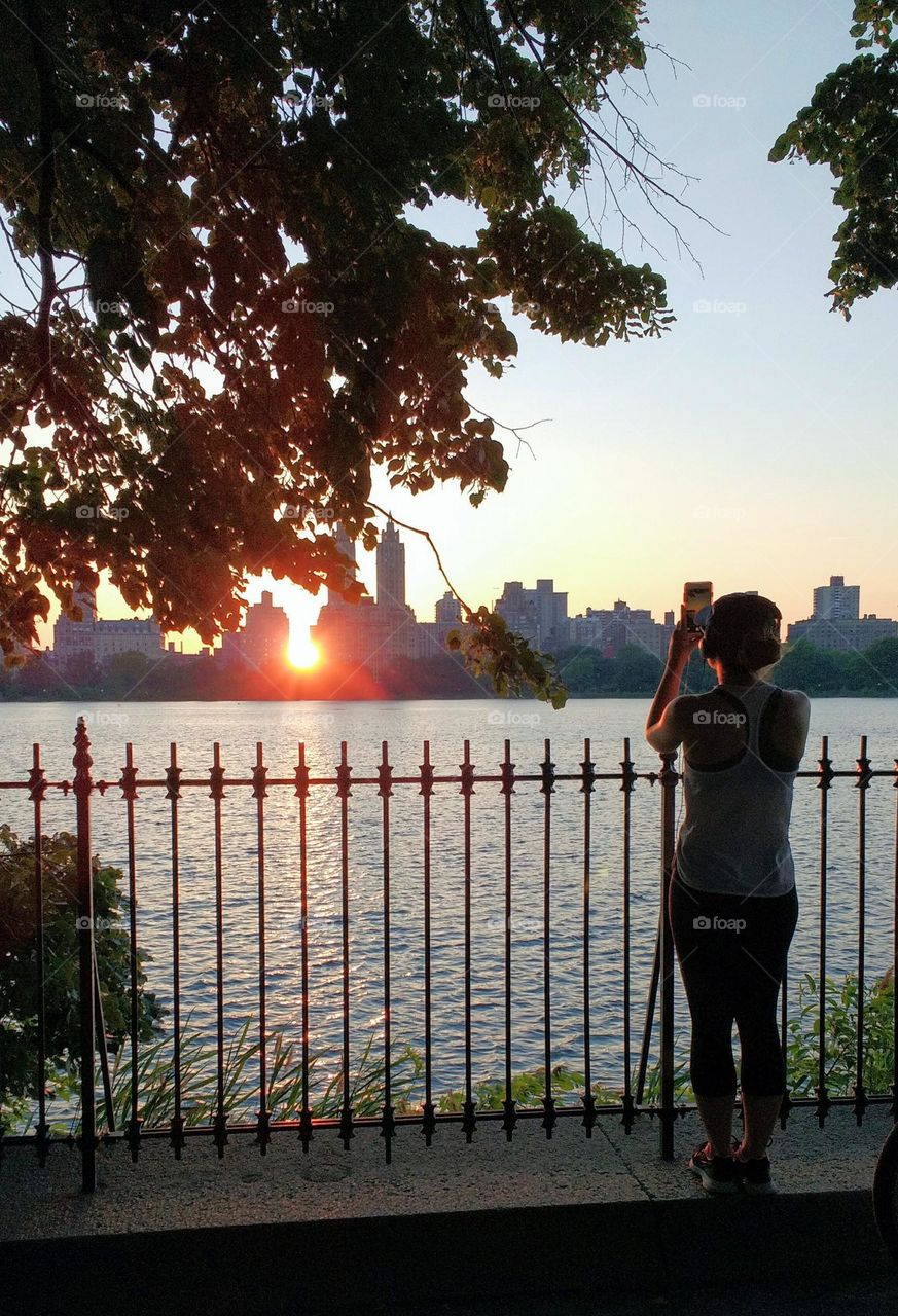 Young Jogger Snapping a Photo of a Sunset NYC in the Summer