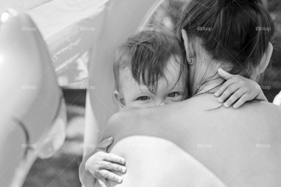 Nice image of a young upset boy cuddling his mum. child looks out of the mother's shoulder