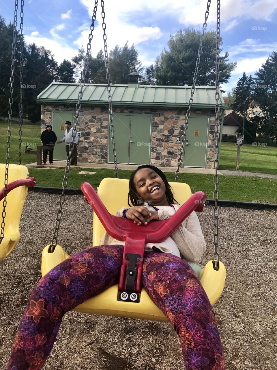Child in Large Playground Swing Smiling