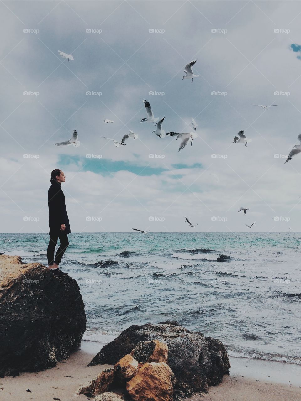 Girl with seagulls at the sea