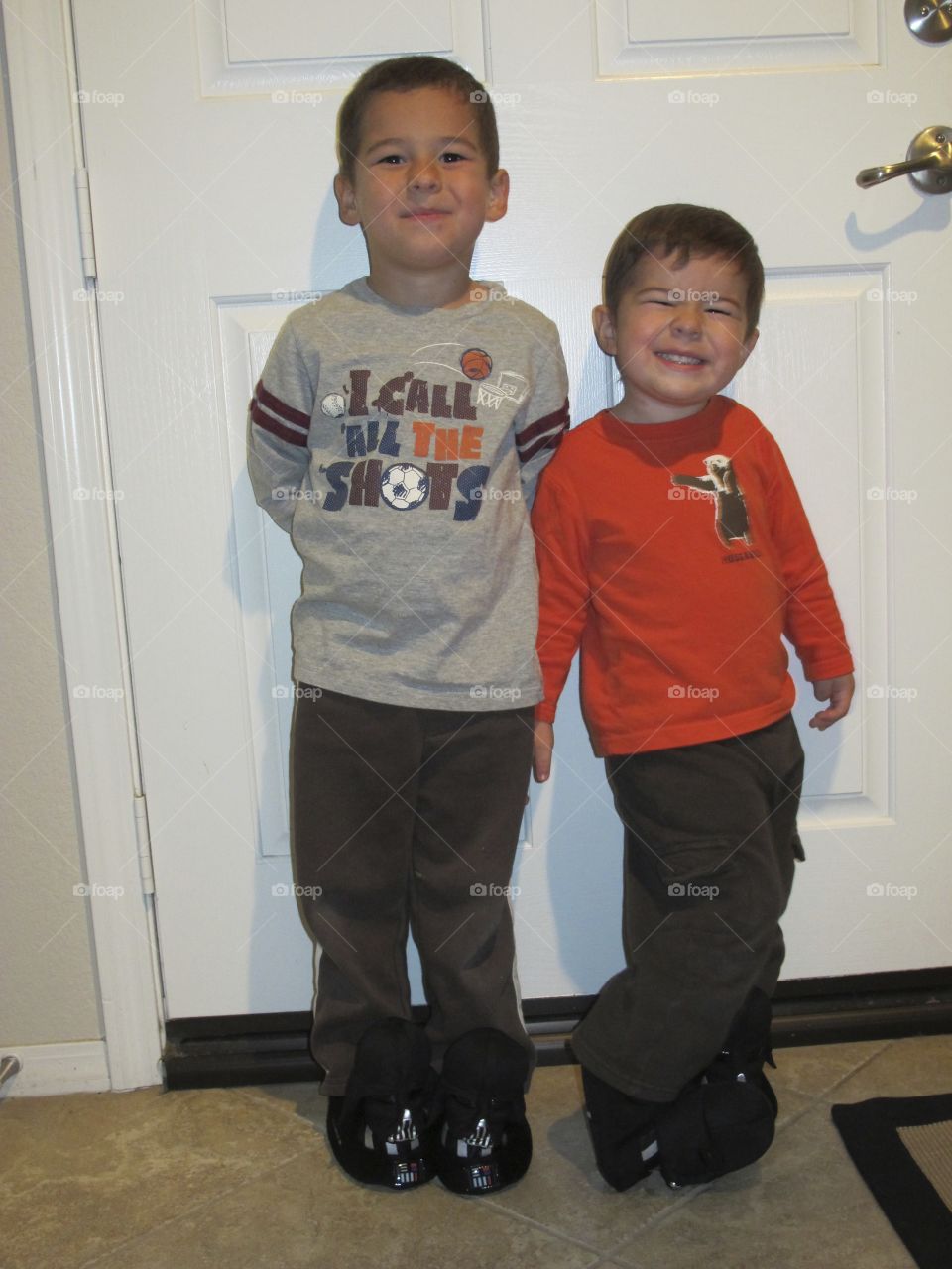 Two brothers standing beside door