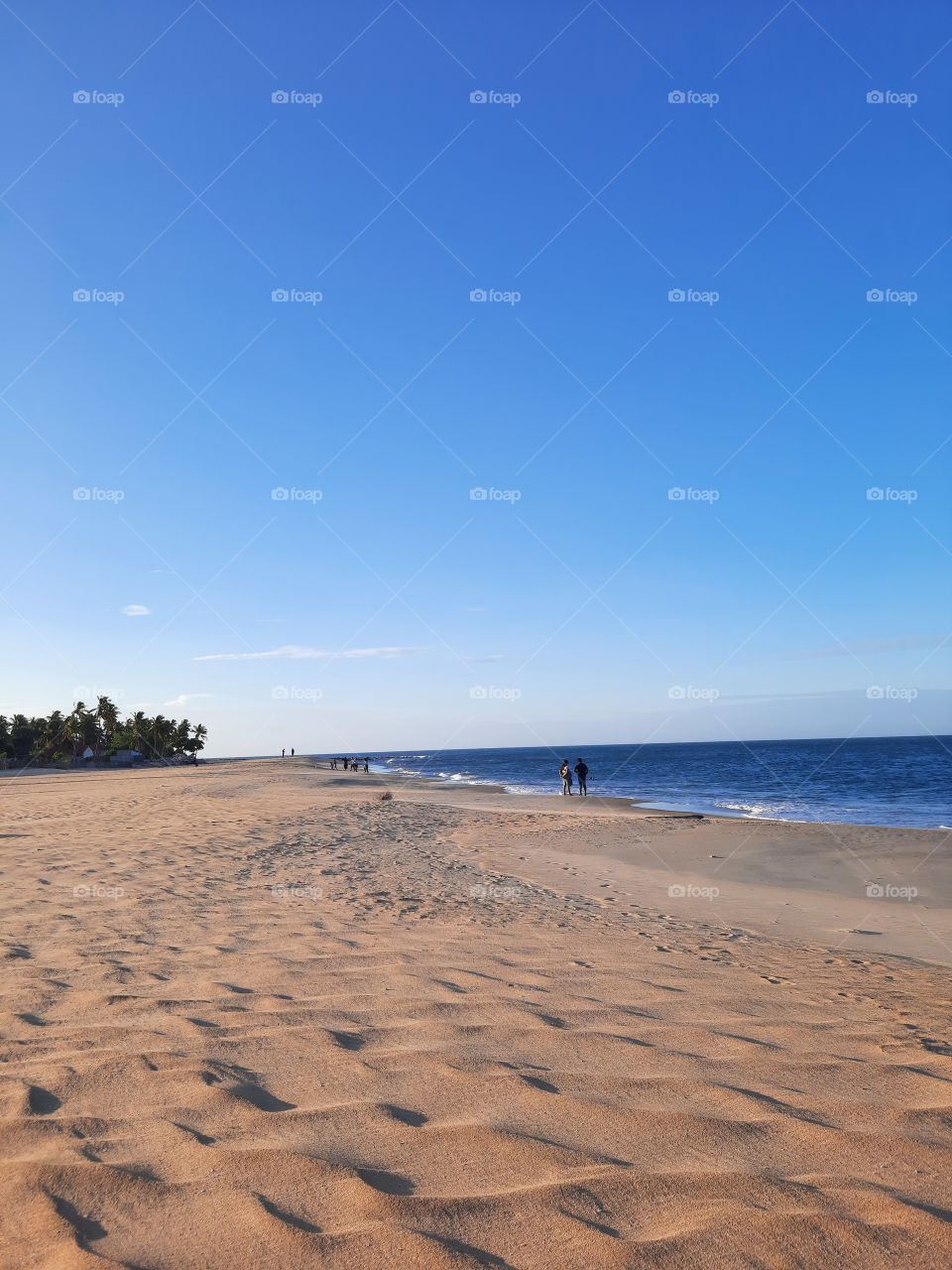 Clam, enjoyable evening on a perfect sunny beach on a perfect summer day with perfect blue waters. People enjoying on a the sandy beach with thier families. Not crowded, perfectly calm and relaxing.