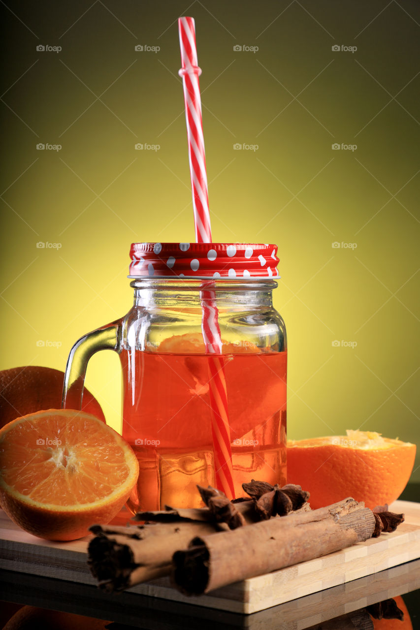 Orange Juice with cut orange in a mason jar with some spices