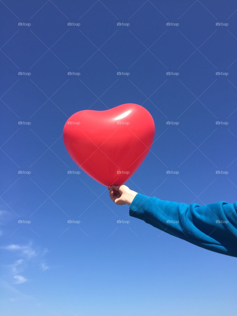 Close-up of hand holding heart shape balloon