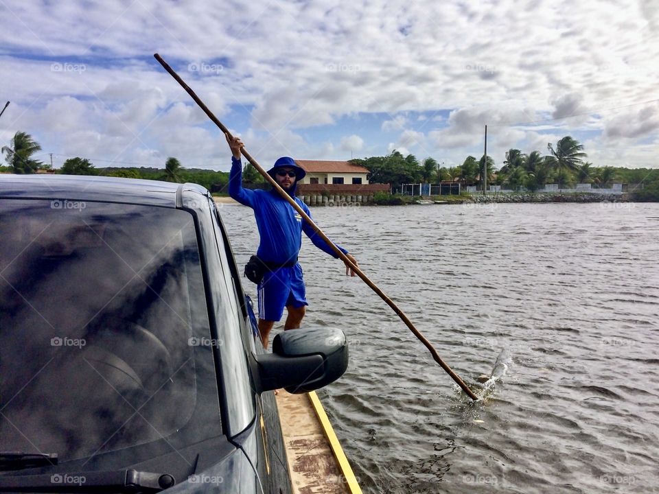 Man hauling a car by ferry