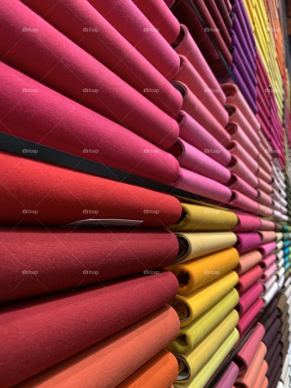 Colourful clothes arranged in a rack inside store