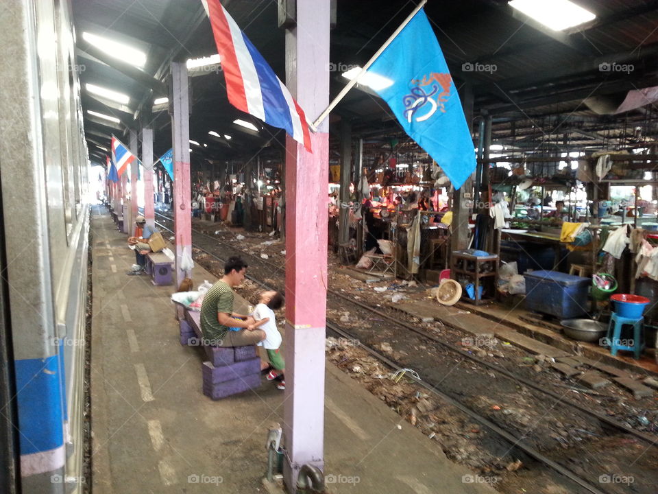 father and son waiting at train station in Thailand