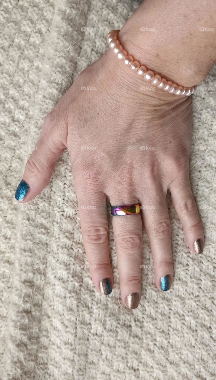 beautiful female hand with accessories ring and bracelet on a white background, beauty accessory