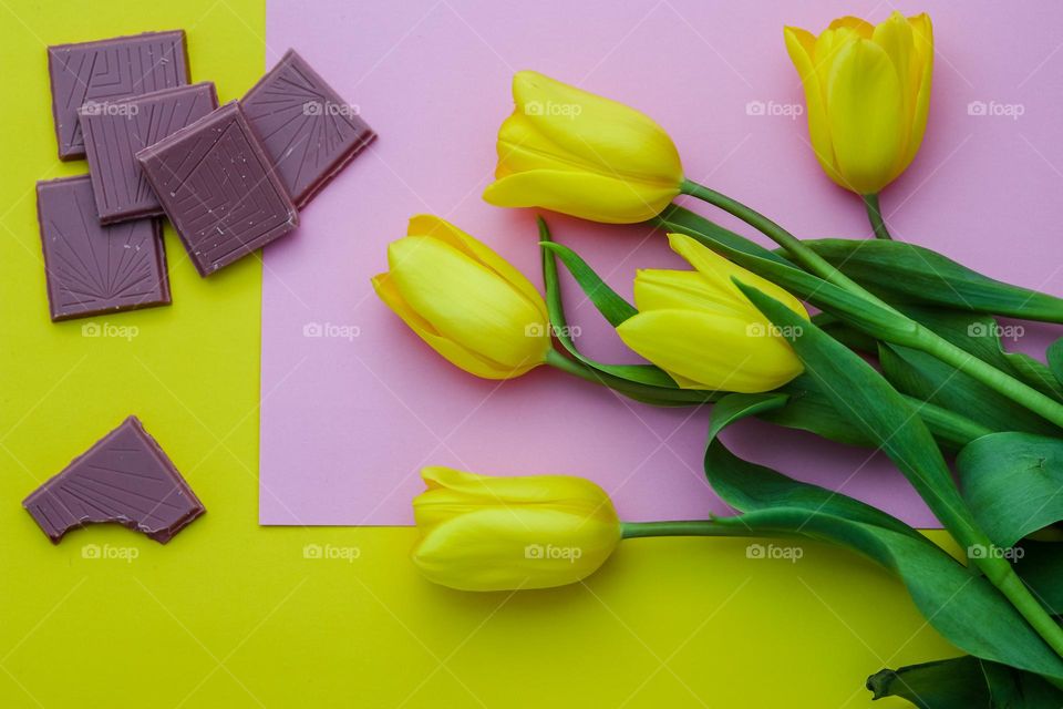 Rectangle chocolate pieces and yellow tulips