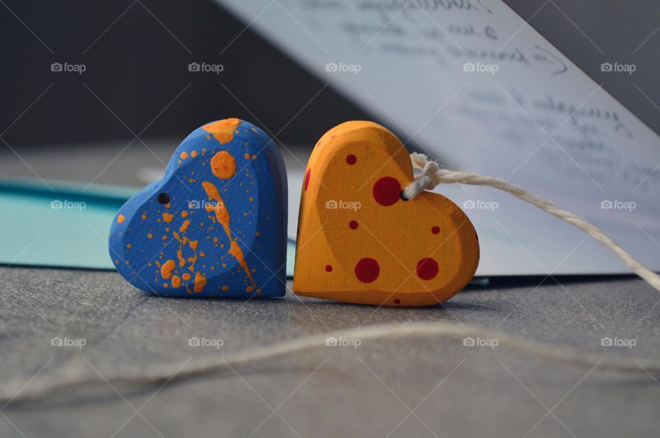 Multicolored wooden hearts near a greeting card