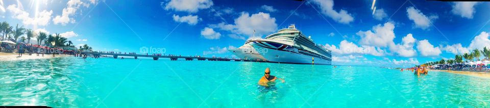 Carnival Sunshine Cruise docked in Grand Turk during our vacation. Blue water, husband swimming 