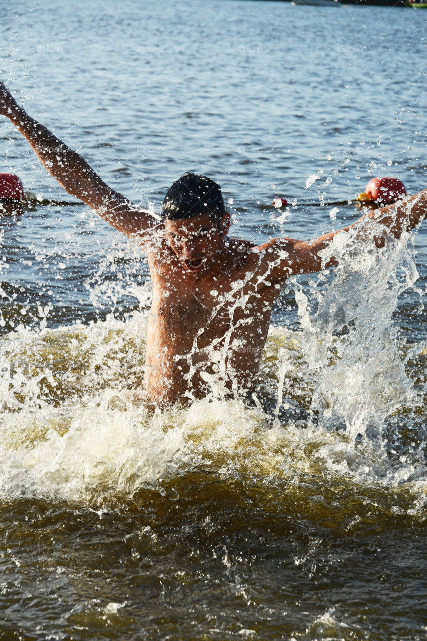 man is jumping into the water with a lot of splash