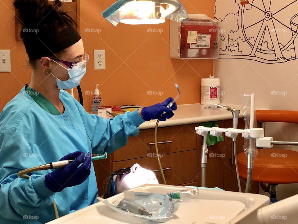 Dentist, dental, hygienist, hygiene, dental hygienist,dental hygiene, tools, teeth, tooth, cleaning, tray, mask, woman, female, gloves, blue, orange, counter, light, brunette, dentist office, office, exam, examination, dental exam, patient, medicine 