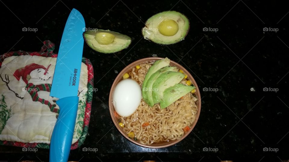 Christmas Snowman pot holder with blue knife on top (can be cropped out and photoshopped). cut avocado and boiled egg on top of bowl of ramen. two halves of avocado laying on top. hearty, healthy, and filling meal. warm for fall months.