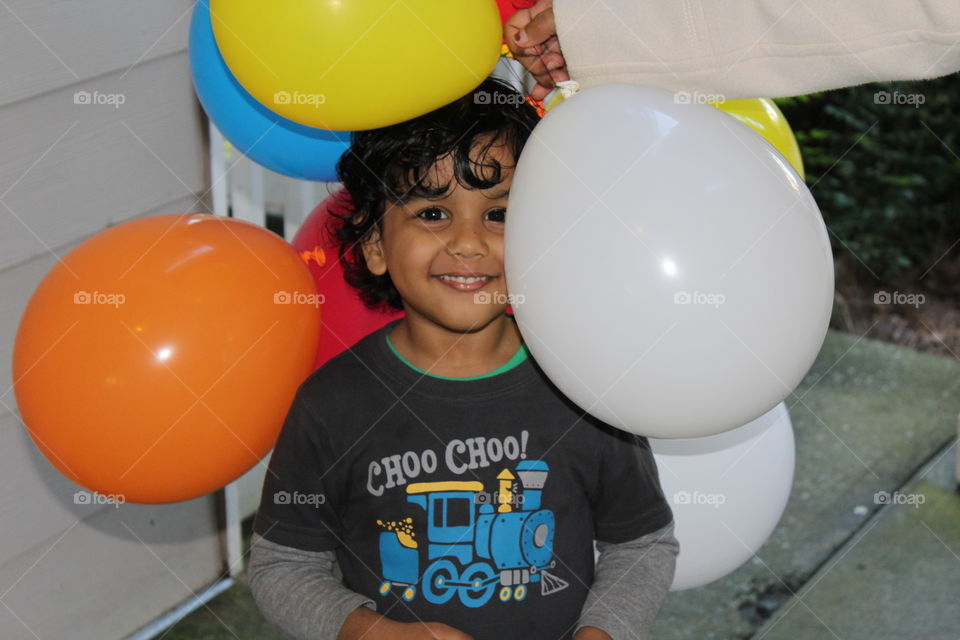 Smiling boy sitting with balloon