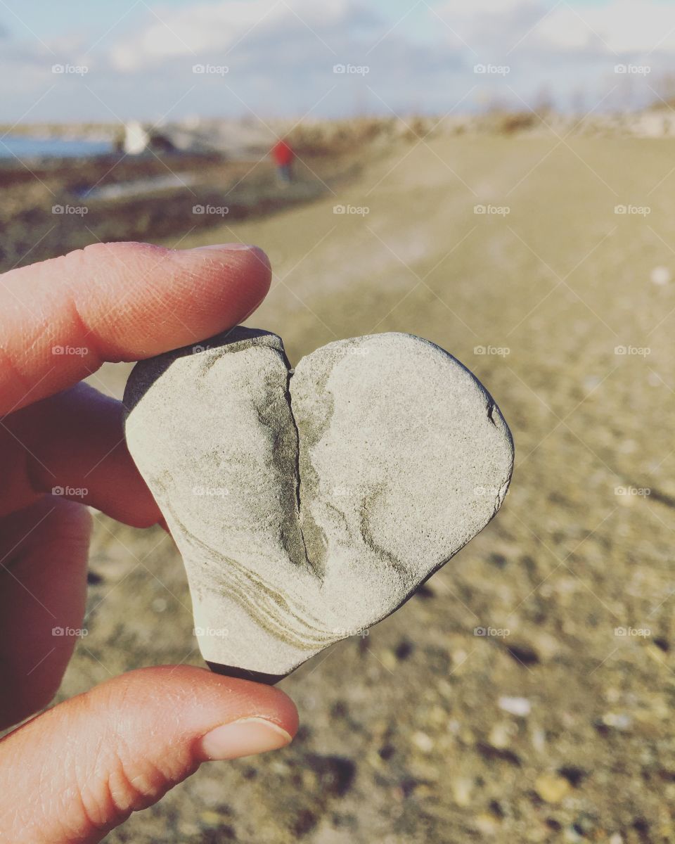 Woman holding heart shape cracked stone