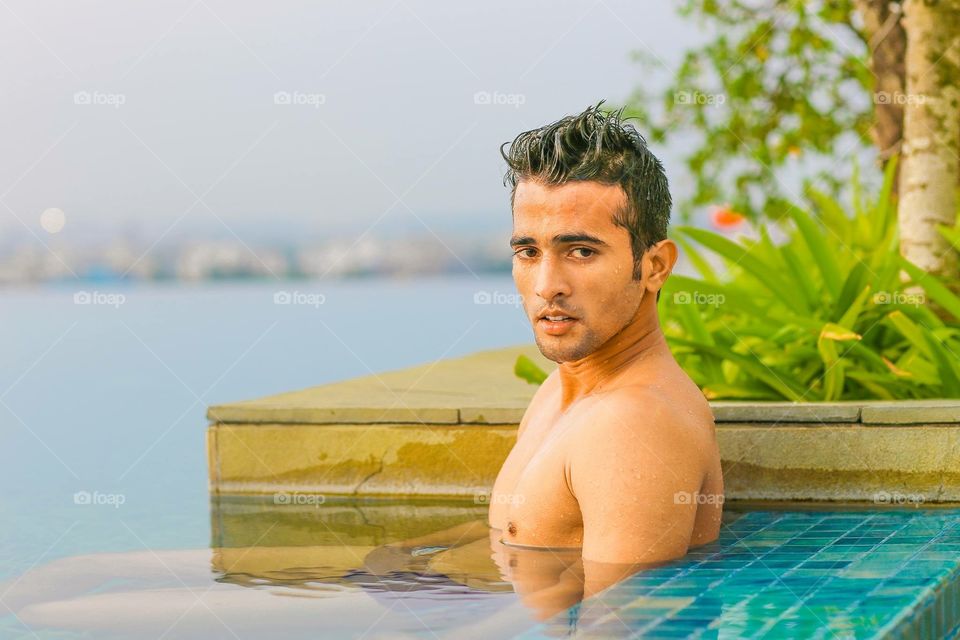 Indian model in the pool. Indian male model in a rooftop pool