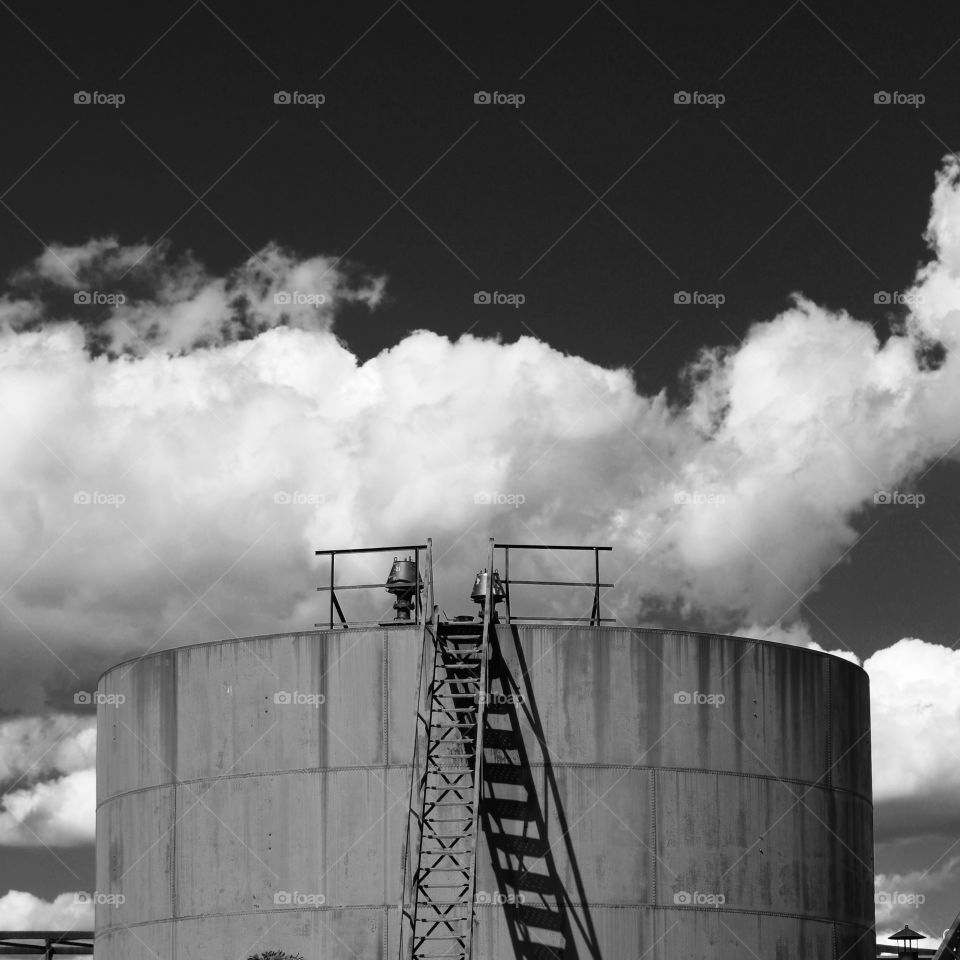 Black and white storage tank with clouds