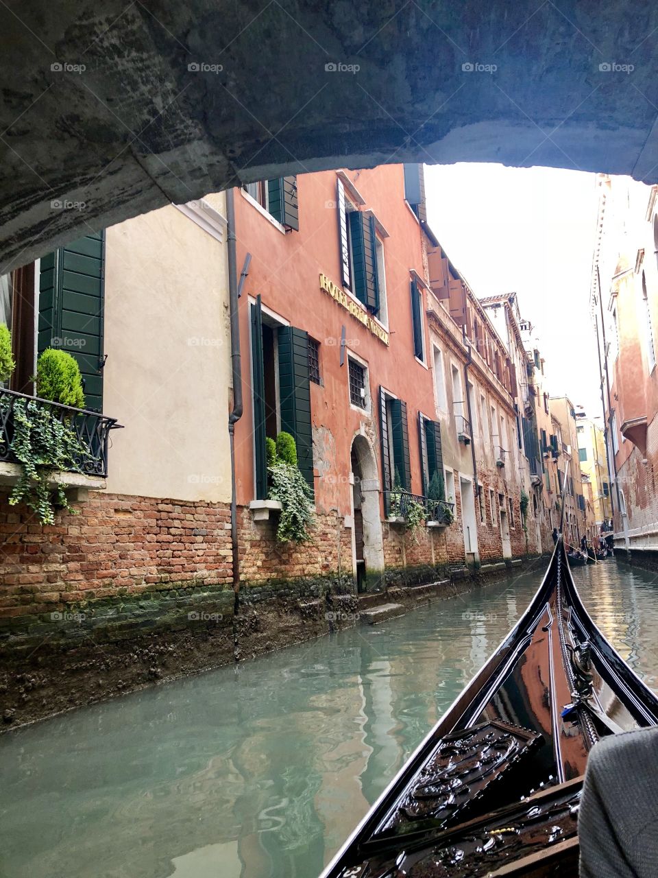 Gondola going under a bridge - Venice, Italy