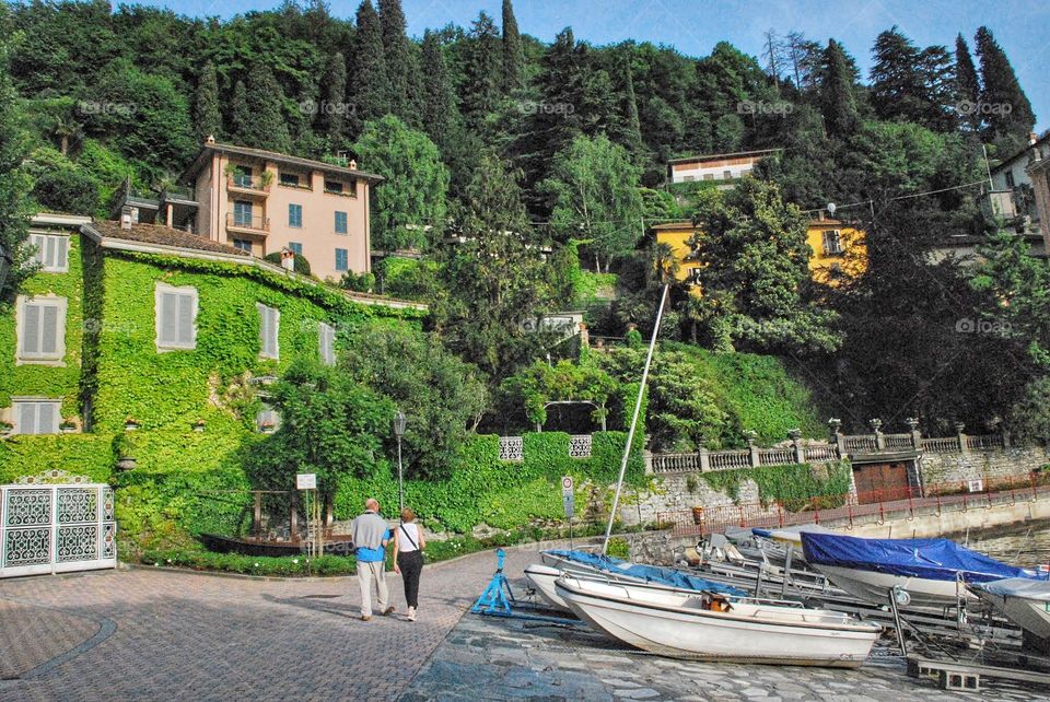 Sailboats at rest. Sailboats on the shore of Lake Como surrounded by ivy covered Italian villas 