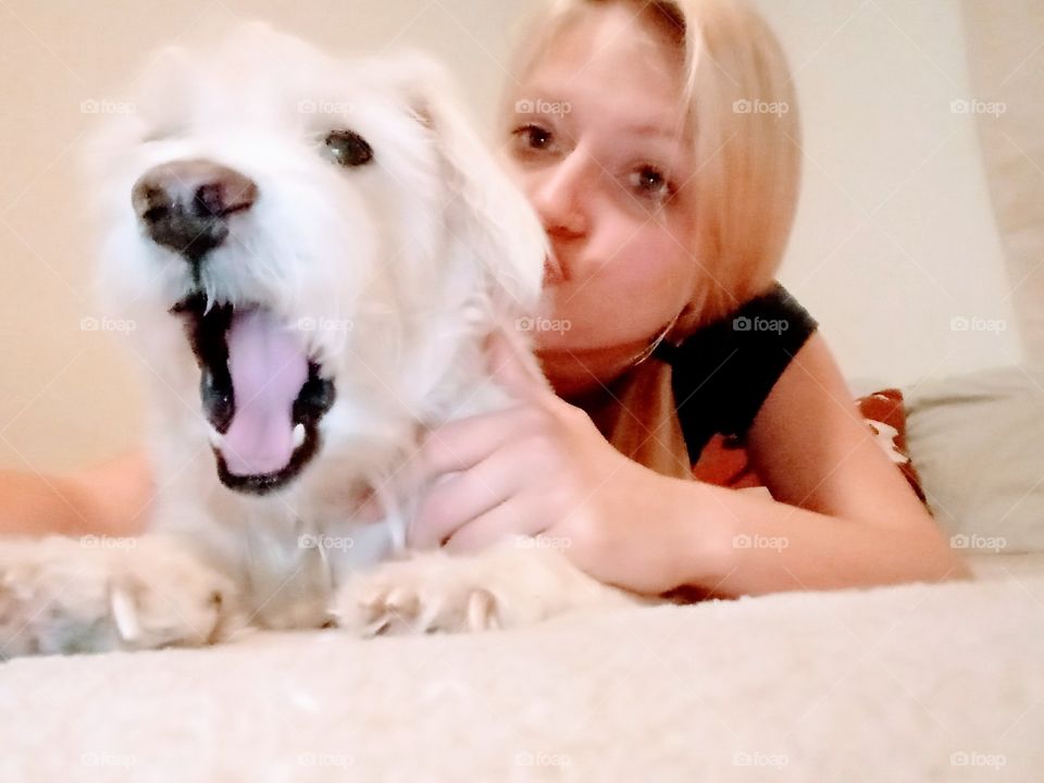 young woman posing with her pet white dog.