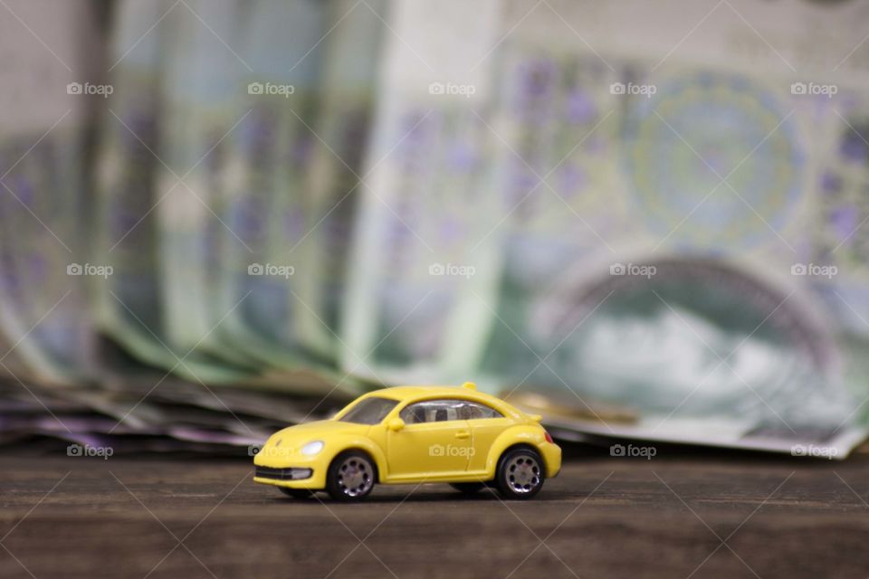 Yellow volkswagen new bettle on the money background
