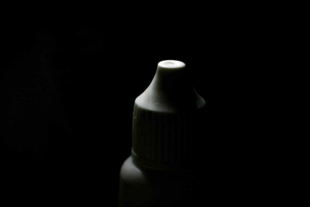Bottle Cap of an eyedrop medicine, zoom macro detail shot. Beautiful strong lighting contrast.