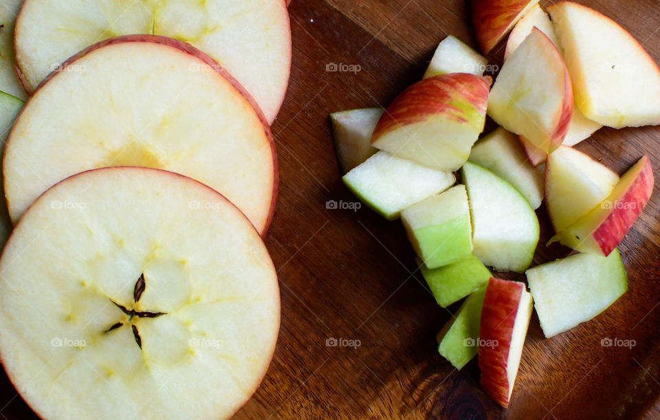 Beautiful Sliced and chopped red and green apples on dark wood in circle shape with star shaped seeds conceptual healthy eating and fresh crisp ingredients gourmet food photography background 