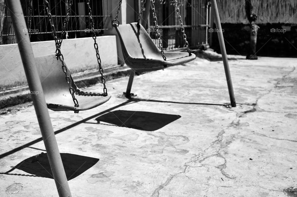 Silent Swing. An abandoned playground near an abandoned school