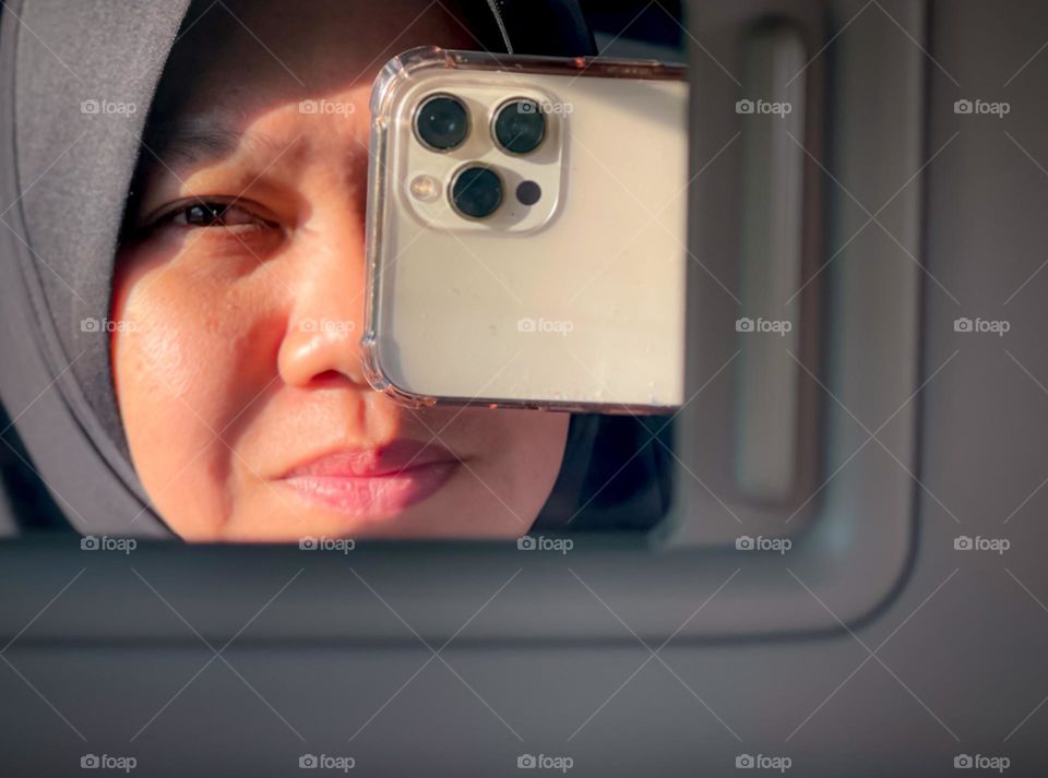 Reflection of self in a car using a smartphone 