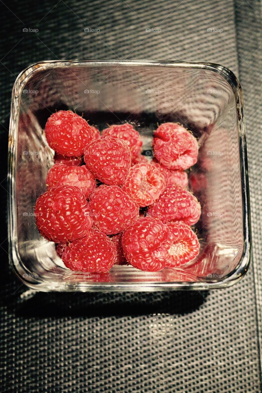 Red raspberries on a clear bowl
