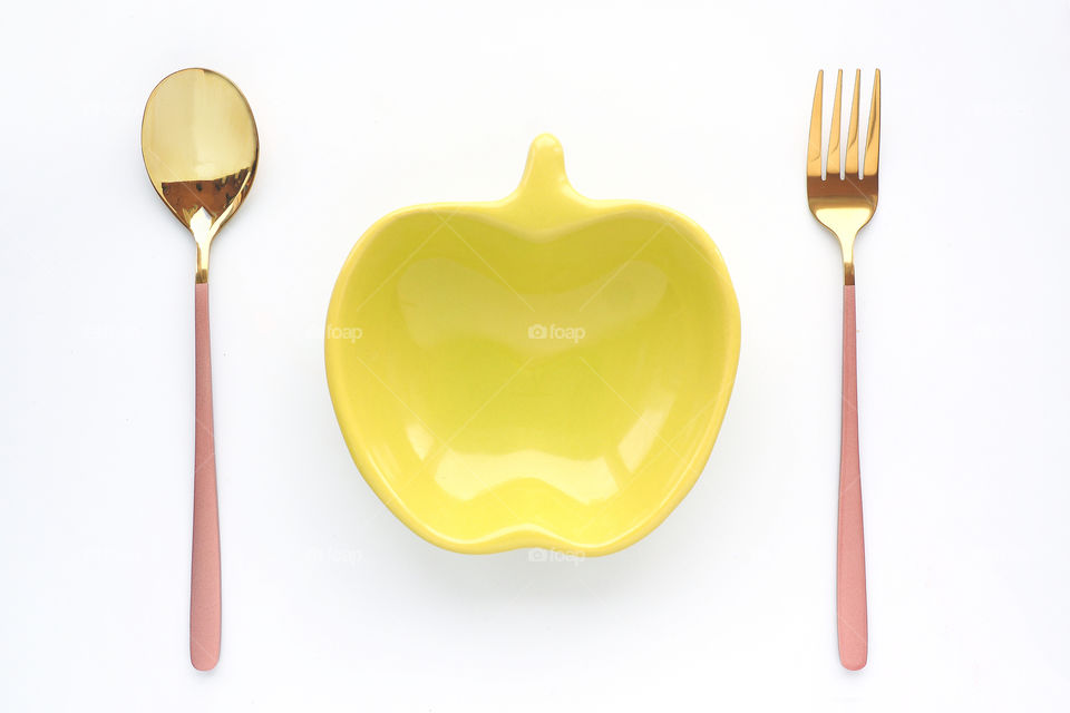empty Green dish in the shape of an Apple and a spoon with a fork. the concept of vegetarianism