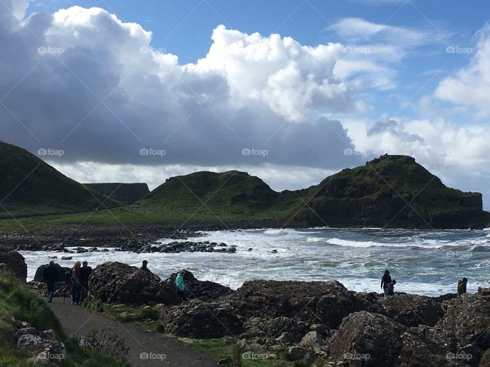 A beautiful landscape photo of a rock shoreline in Ireland with mountains in the distance 