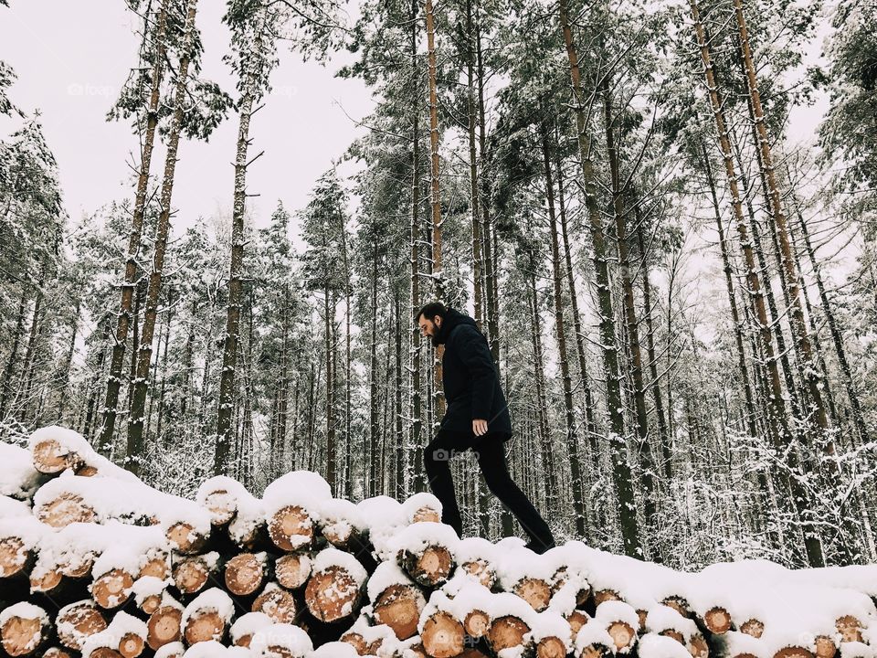 Man walking on frozen wooden stack