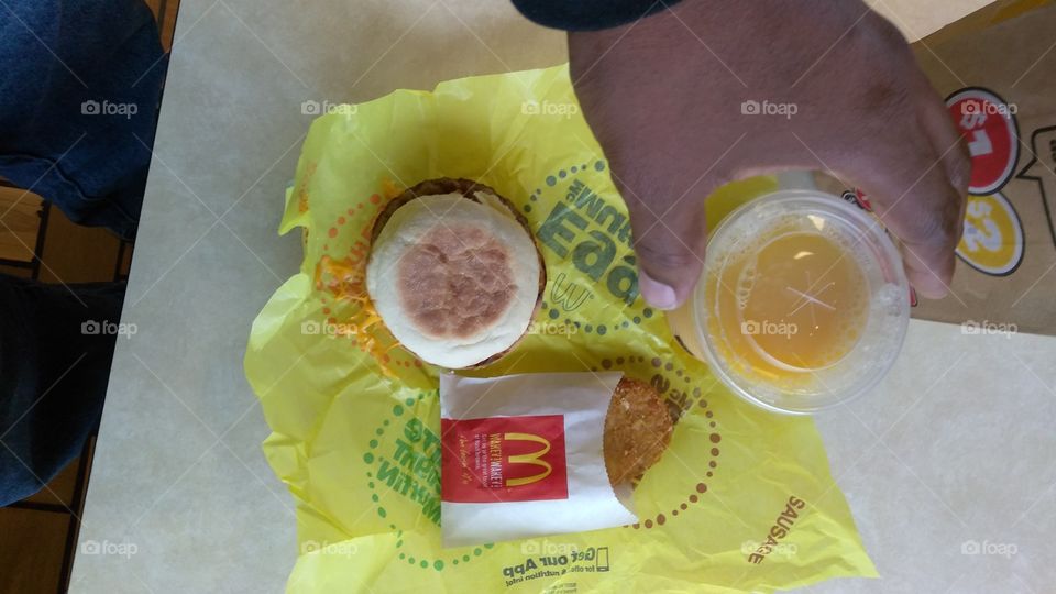 morning breakfast, McDonald's sausage egg McMuffin, hash brown, orange juice. Flat lay